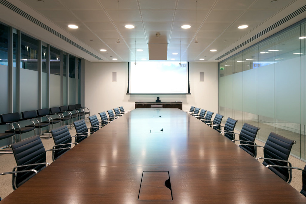 Empty boardroom with a long table and the chair at the head unoccupied